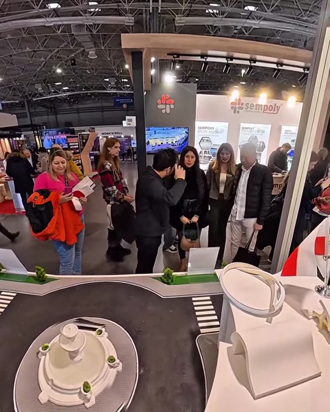 Partecipanti riuniti attorno allo stand che presenta colonne e pannelli decorativi