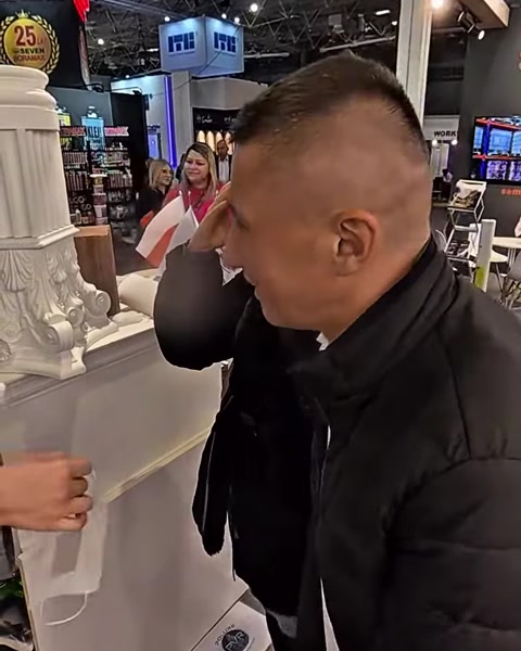 Un uomo esamina da vicino la texture superficiale di una colonna in poliuretano allo stand