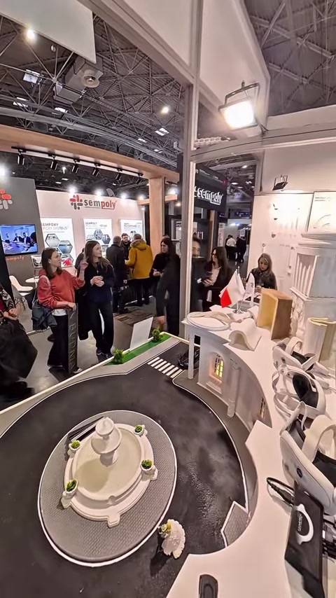 Visitors gather around booth displaying column and molding profile boards