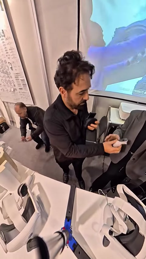 Man holding VR controller while screen displays 3D architectural model