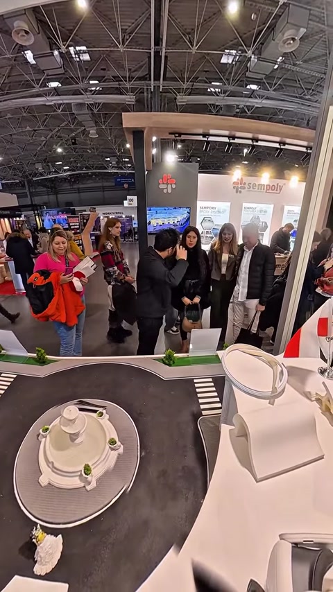 Attendees gathered around booth showcasing column and panel displays