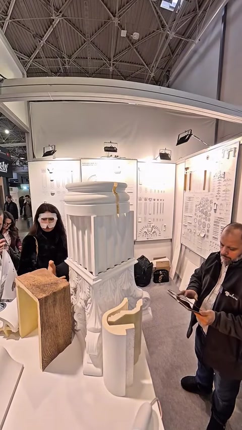 Woman examining molding profile board mounted on booth display wall