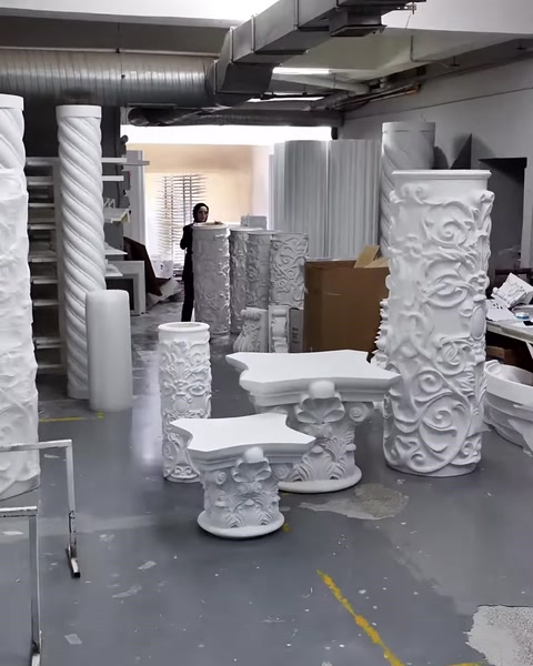 Column shafts, capitals, and bases can be seen throughout the workshop.