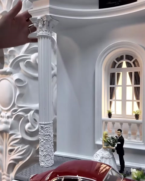 A scale column model held in the hand is compared with a real column.
