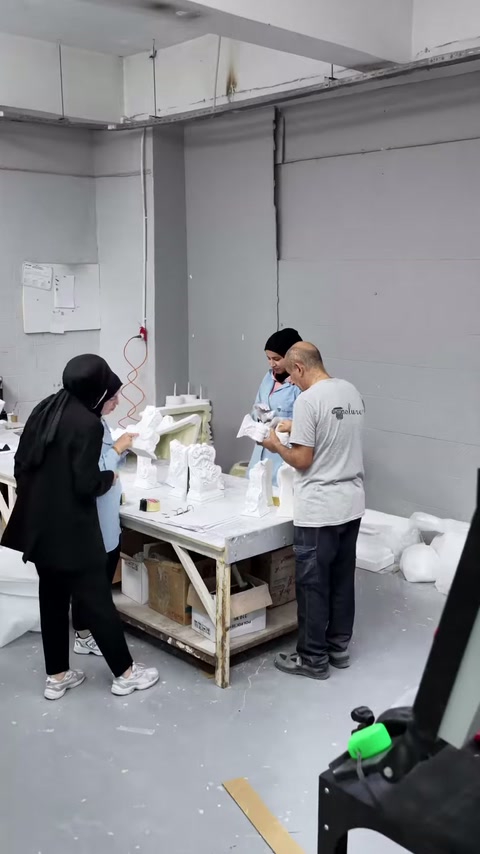 Il team del laboratorio lavora su piccoli capitelli di colonna e elementi decorativi.