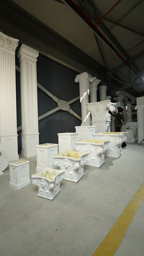 Assorted capitals, bases and shafts arranged across the production floor