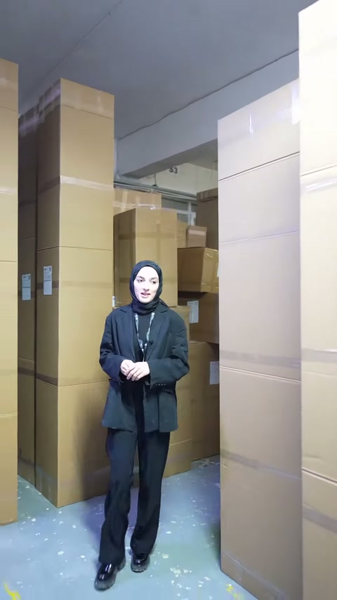Depolama bölümünde yürüyen sunucu, paketlenmiş ürün stoklarını gösteriyor.