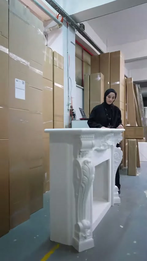 Atölye girişinde beyaz süslemeli şömine gövdesi sunucuya eşlik ediyor.