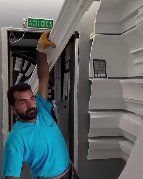 Un operatore solleva la grande cornice ad arco verso l'apertura interna