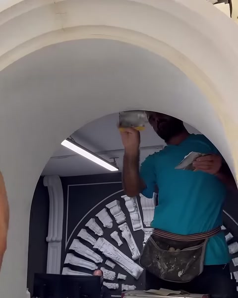 Un operatore copre con lo stucco la zona di giunzione sulla superficie inferiore dell'arco
