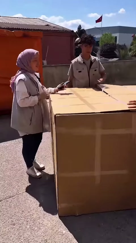 I lavoratori si preparano intorno al grande scatolone di cartone davanti al laboratorio