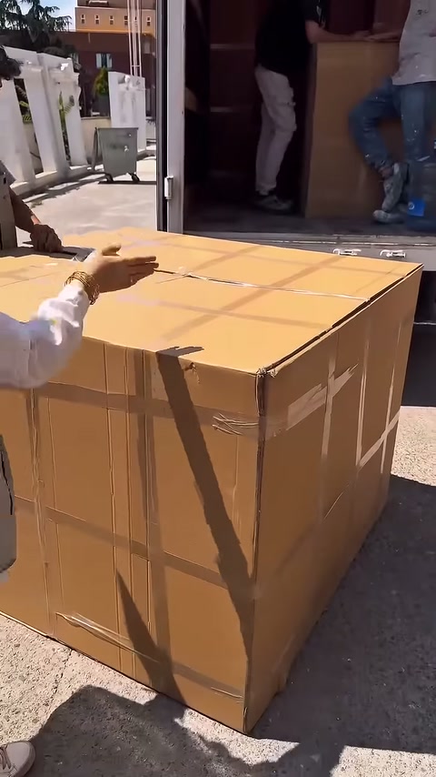 Un lavoratore si prepara ad aprire la parte superiore del grande scatolone