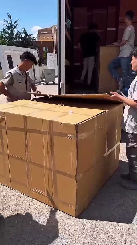 Un lavoratore solleva il coperchio superiore dello scatolone verso dietro