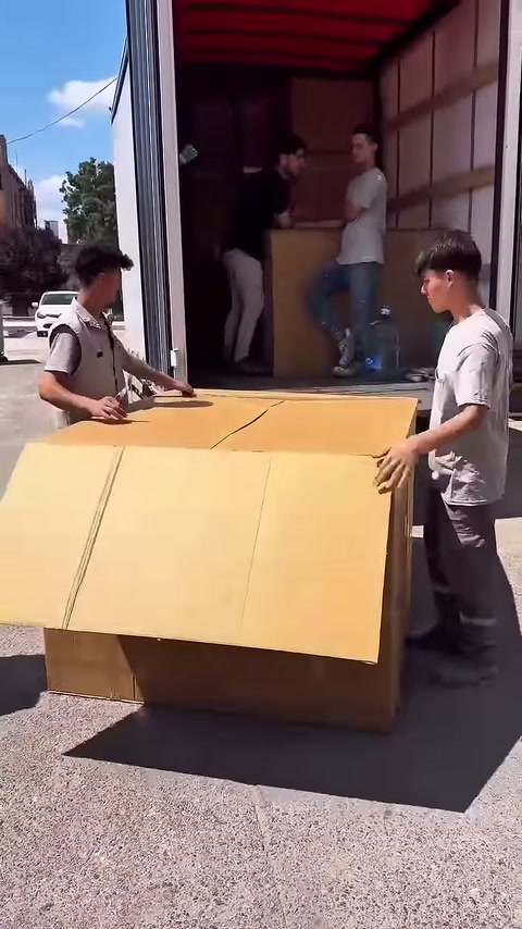Un lavoratore tira il pannello di cartone anteriore verso di sé per abbassarlo