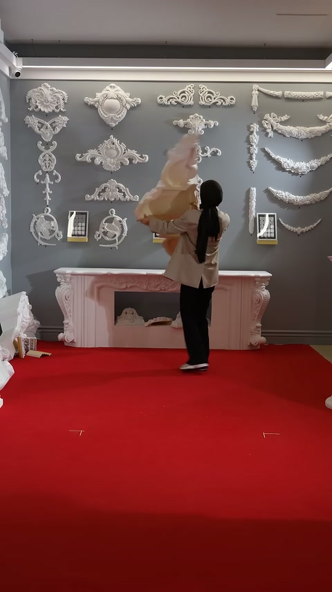 Large white decorative element is lifted into the air in the showroom display.