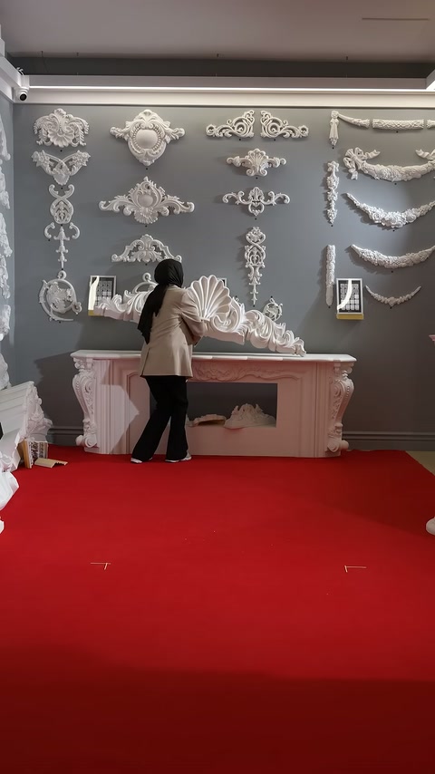Presenter demonstrates the product in front of a pink fireplace and wall embellishments.