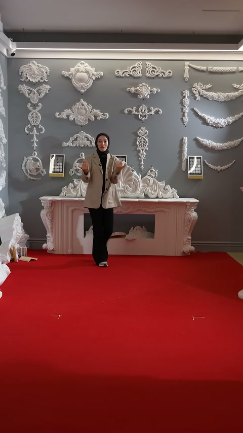 Presenter explains the product through hand gestures in front of the pink fireplace.