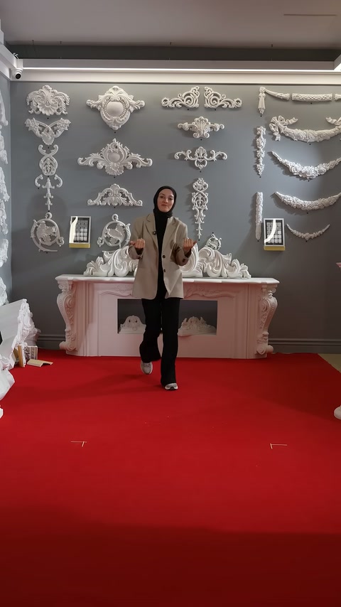 Presenter prepares to introduce decorative columns in front of wall ornaments.
