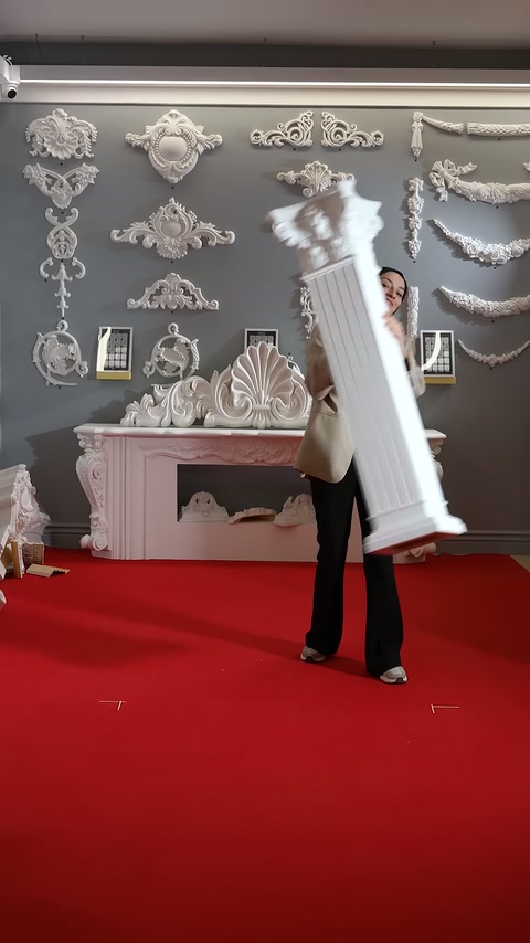 Fluted white decorative column is displayed suspended above the showroom floor.
