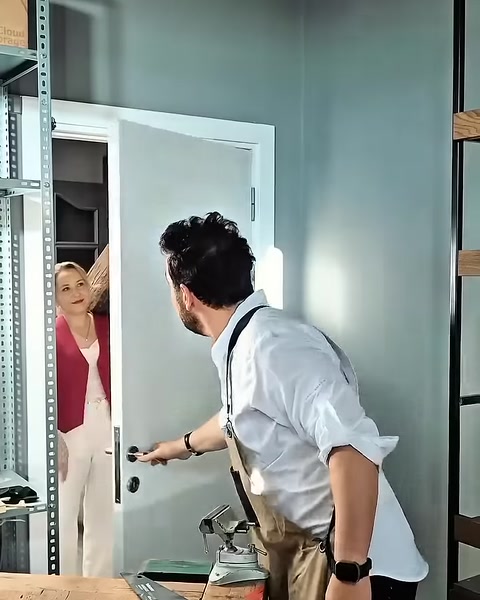 Un artigiano riceve una trave decorativa in poliuretano effetto legno da un collega all’ingresso del laboratorio