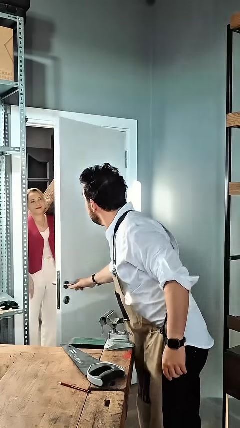 Craftsman receives wood-look polyurethane beam from colleague at workshop entrance