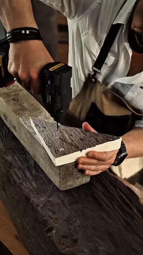 Close-up of drill fastening corner joint on textured beam