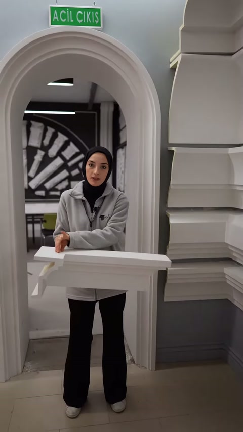Una cornice in poliuretano viene mostrata con entrambe le mani all'altezza del petto.