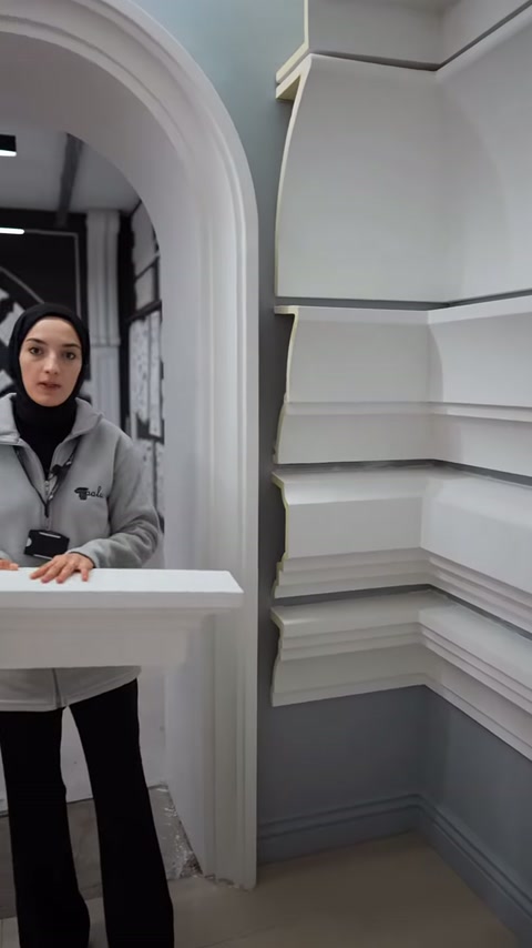 Il presentatore indica con la mano il bordo superiore della cornice marcapiano.