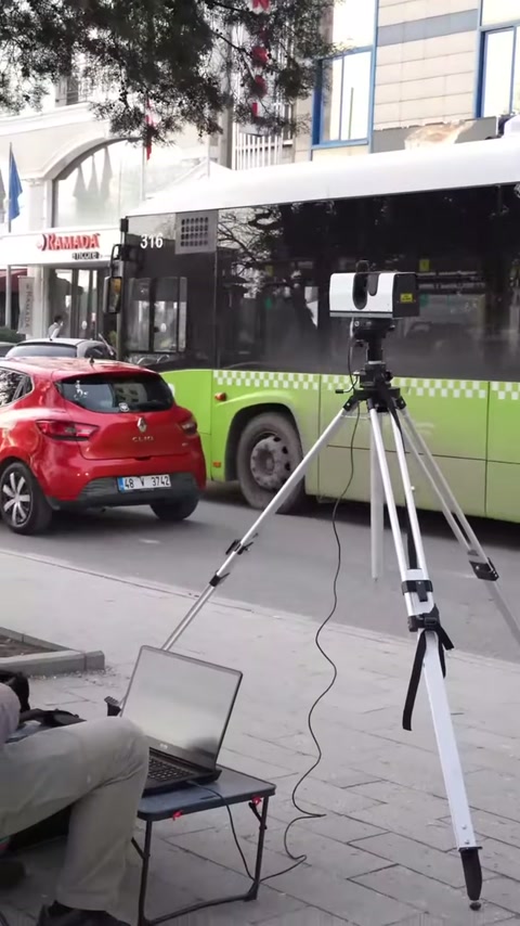 Uno scanner su treppiede esegue la misurazione della facciata dell'edificio nel centro urbano.
