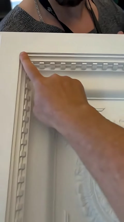 Decorazioni in rilievo disposte in sequenza sulla cornice del pannello mostrate da vicino