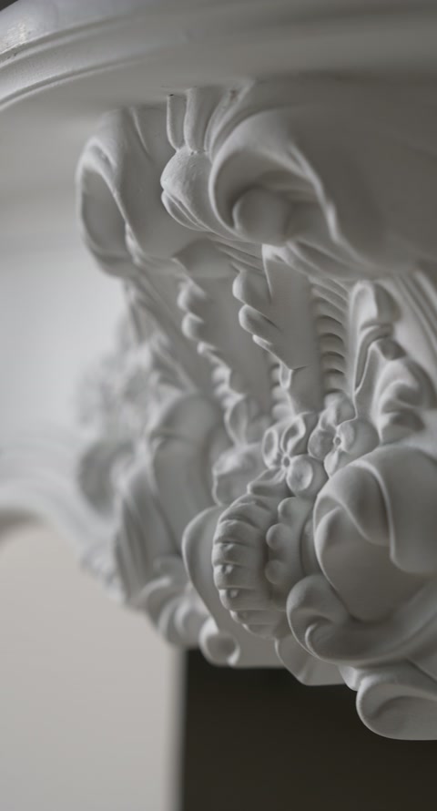 Macro detail reveals layered leaves, blossoms, and scrolls on the corner.