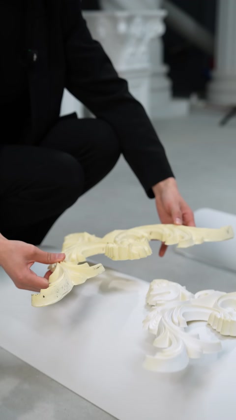 The curved profile of a decorative ornament is shown while held from the side.