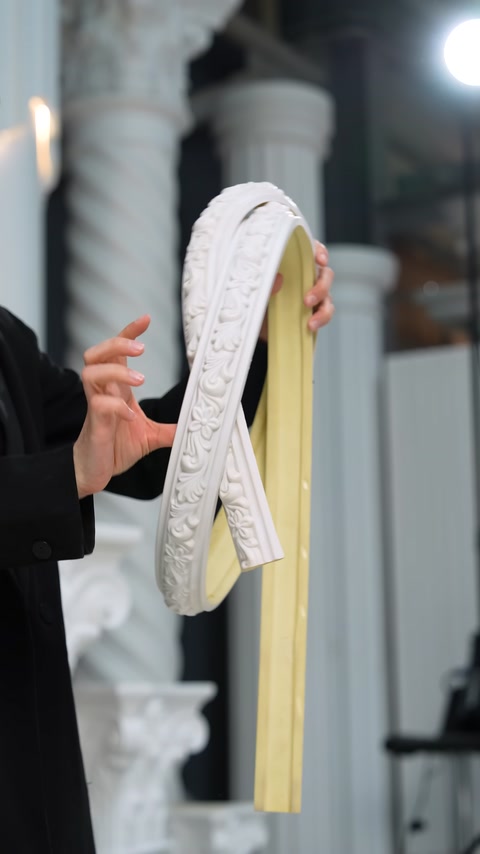 A white flexible moulding is shown up close in a sharp curve.