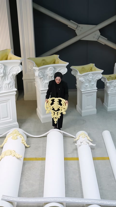 Sarı göbek süslemesi, beyaz kavisli sütun yüzeyine doğru indiriliyor.