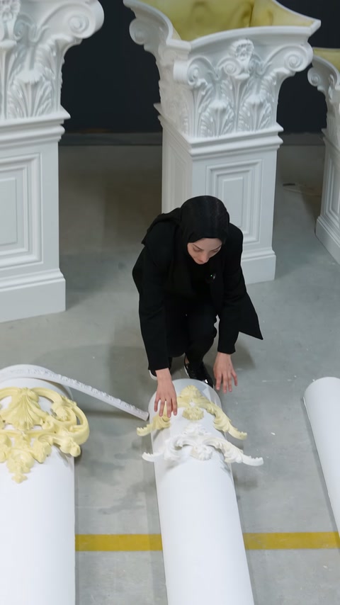 Beyaz motifli süsleme yuvarlak gövde üzerinde iki elle tutuluyor.