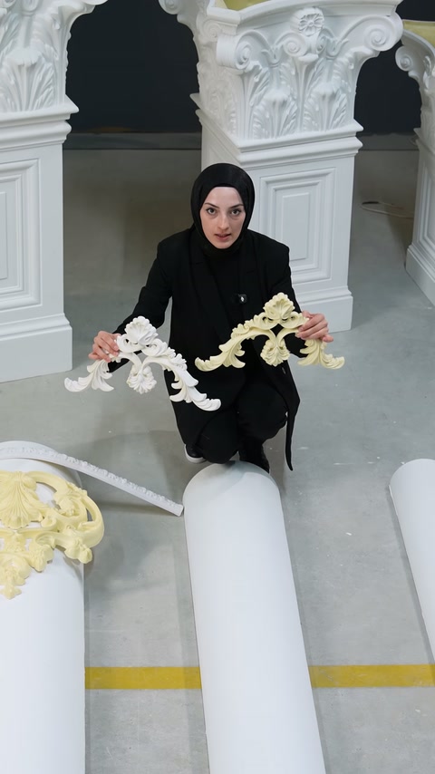 Sarı ve beyaz dekoratif motifler sütunlar arasında yan yana sunuluyor.