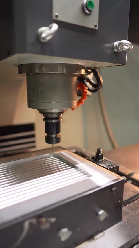 A milling head precisely machines the surface of a grooved panel mold