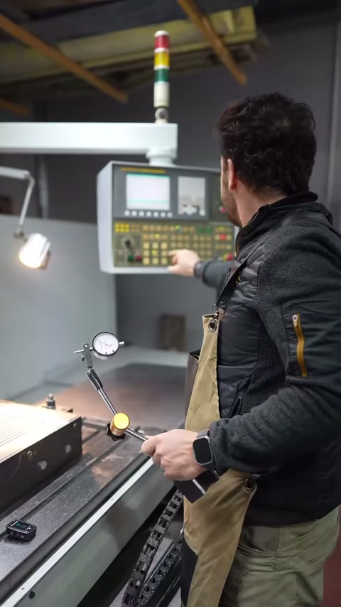 Production worker monitors machining steps from the machine screen