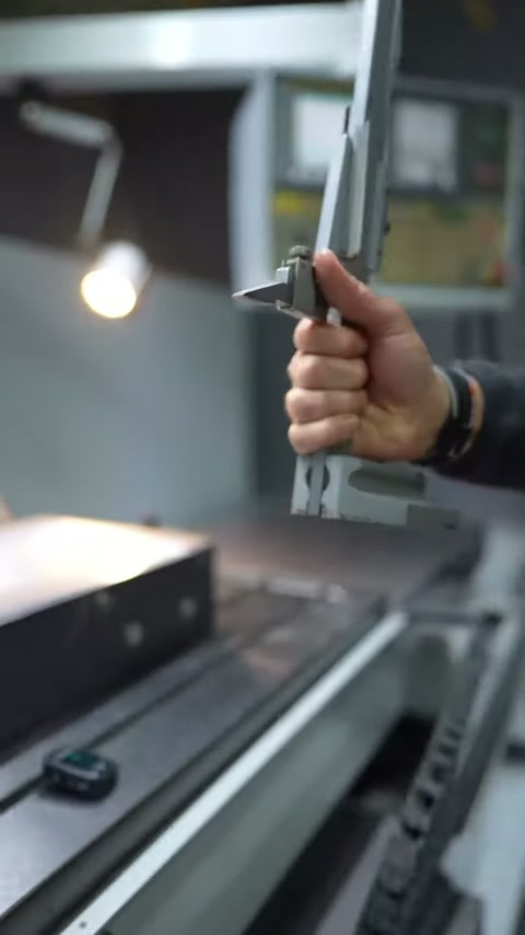 Measurement arm is lowered toward the panel surface by the operator's hand