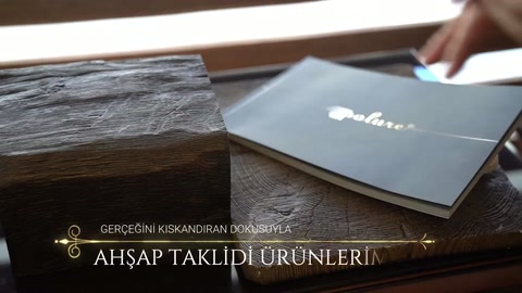 Sul tavolo sono visibili una trave decorativa in poliuretano effetto legno e un catalogo prodotti.
