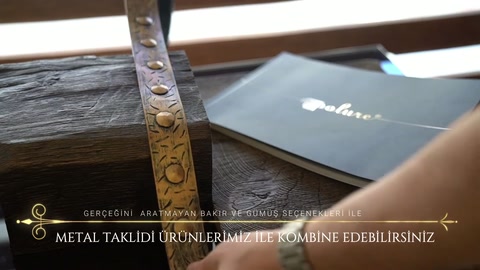 La fascia ornamentale in metallo viene tenuta ferma a mano sulla superficie della trave.
