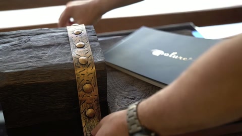 Le mani allineano la fascia in rilievo sulla trave con texture effetto legno.