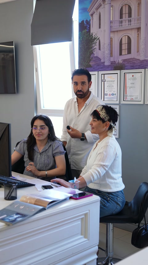 A standing expert provides information about decoration options to seated designers.