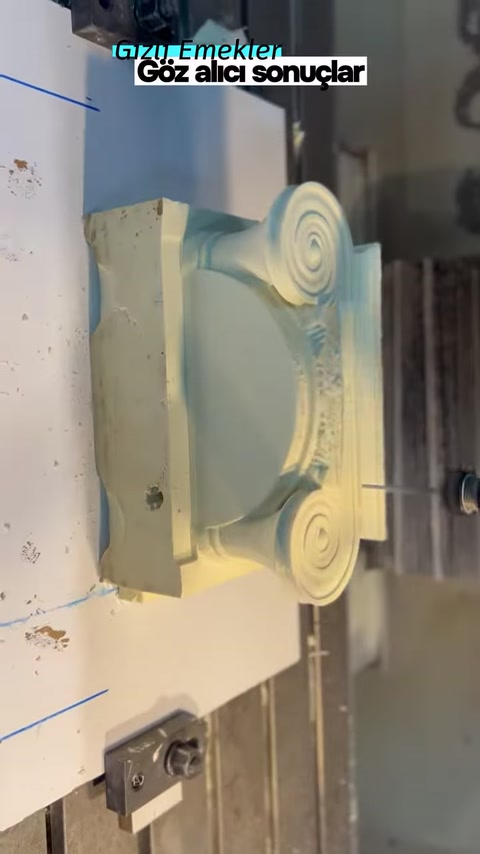 The production machine is shaping the curved central section of the column capital