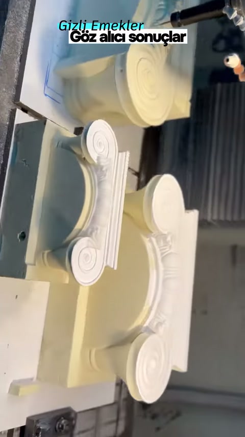 Ionic capital on the workshop bench viewed from the front near the machine