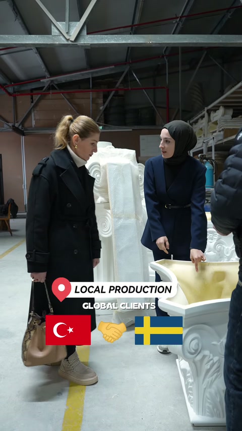 Nell'area di produzione viene esaminato un grande elemento decorativo curvo.