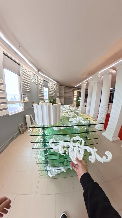 Showroom view featuring a glass display table and rows of columns