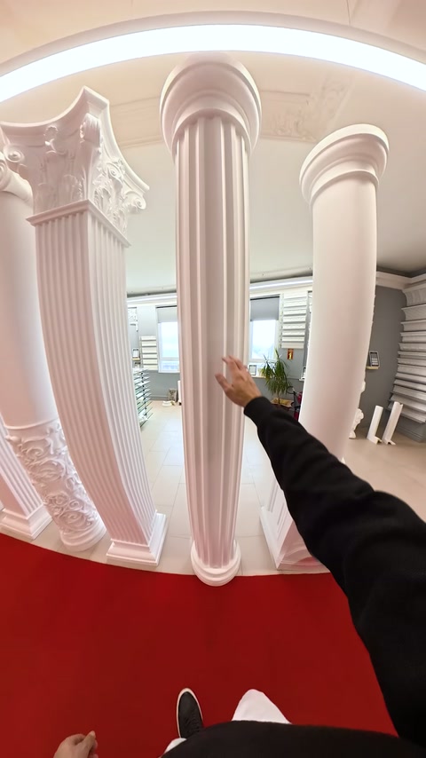 El, showroomdaki ince yivli sütun gövdesini işaret ediyor