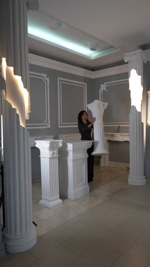 Showroom interior combines decorative columns, wall moldings, and ceiling details.