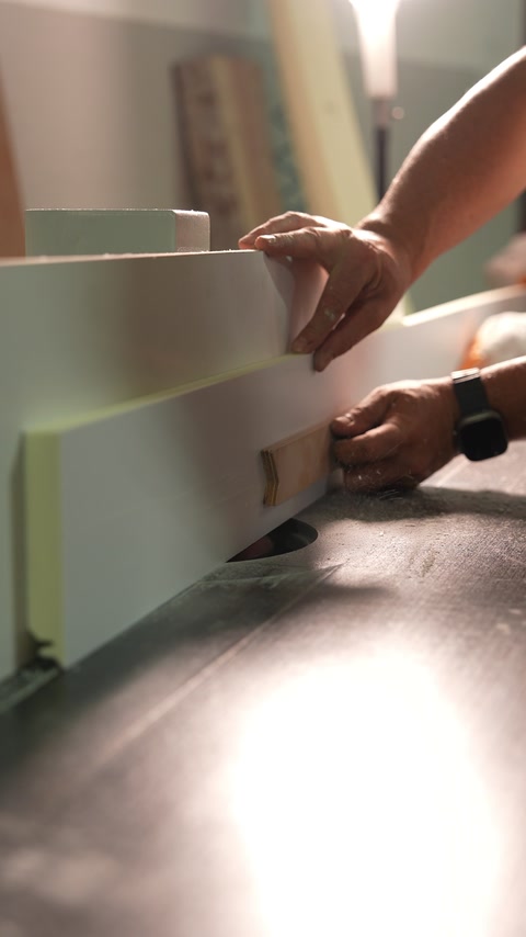 Hands fit a decorative profile against a large architectural panel.